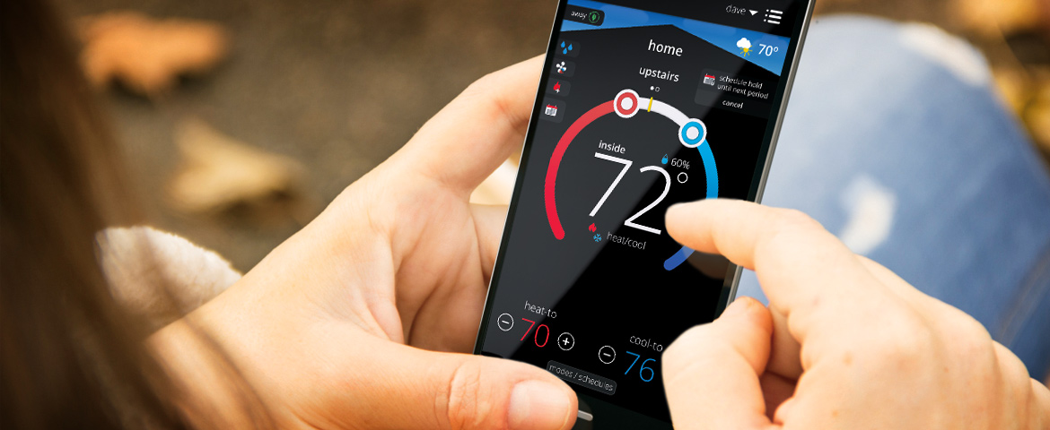 Person holding smartphone with the Lennox iComfort app